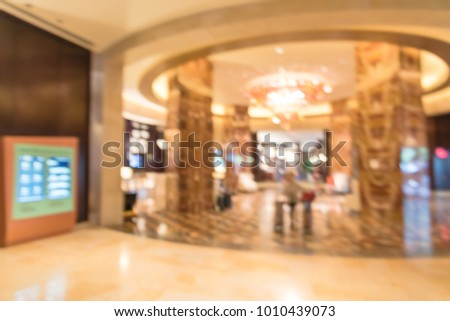 Blurred luxury lobby interior, digital signage board, marble pillars.