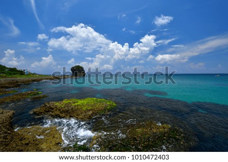 Taiwan, Kenting city seaside, the impact of waves on the lichen Reef rocks, in the blue sky is a beautiful picture and journey.