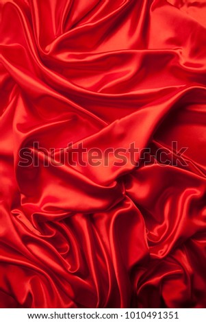 close-up view of a red piece of satin fabric. Minimal color still life photography 