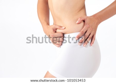 Closeup of a  young lady checking her fats against  white background