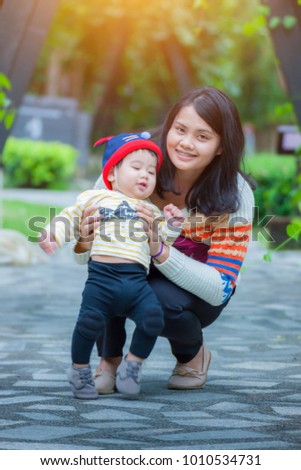 Mother and little asian baby boy in  the nature park. Concept of friendly family and of summer vacation.