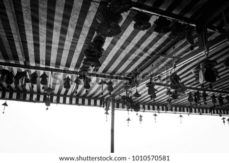 Wooden chinese objects hanging to the striped ceiling (Kunming, Yunnan, China)
