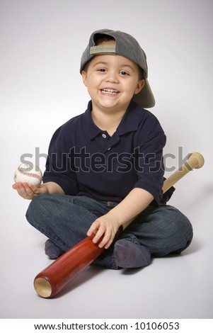 Young hispanic boy with a baseball bat and ball