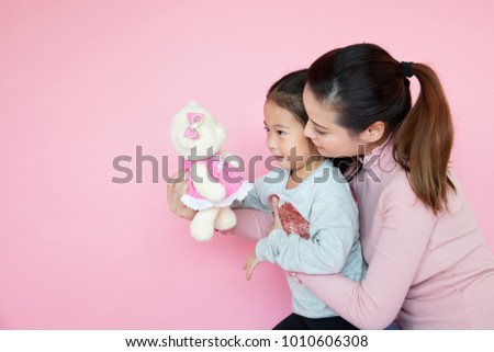 Asian mother and child girl playing, kissing and hugging