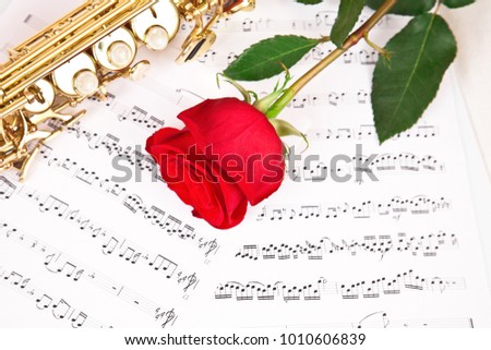 Musical notes and saxophone with red  rose