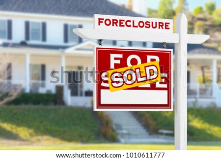 Left Facing Foreclosure Sold For Sale Real Estate Sign in Front of House.