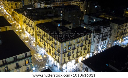 Aerial night view of a residential building in Via Scarlatti, in the Vomero district in Naples, Italy. The lights illuminate the street and people walk under the buildings.