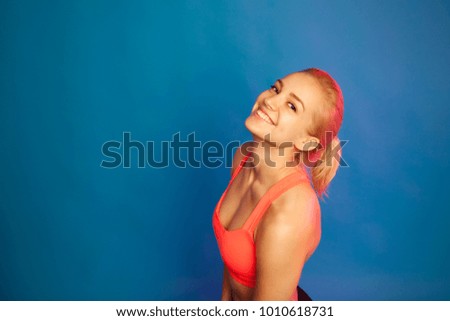 sports girl posing on a blue background. Place for text