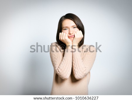 tender woman bored, in a pink sweater, isolated against a background, studio photo
