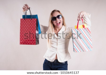 adult woman in a jacket with bags for shopping in sunglasses jeans studio
