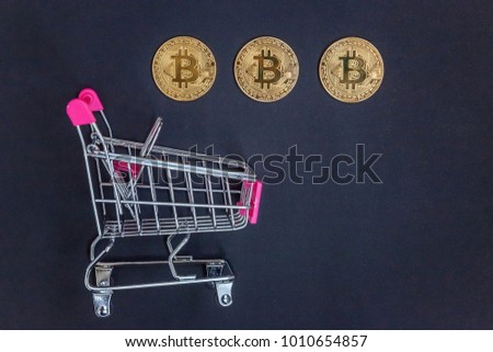 Stack of coins bitcoin in mini shopping cart toy, concept of mining. Electronic virtual money for web banking and international network payment. Symbol of crypto currency