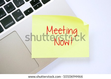Meeting Now! on sticky note pasted on keyboard. Top view design