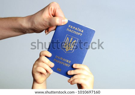 Blue Ukrainian passport in the hands of the child and the woman.