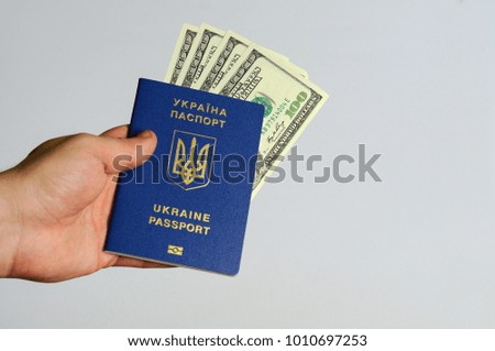 Blue Ukrainian passport with dollars in the hands of a man. Isol