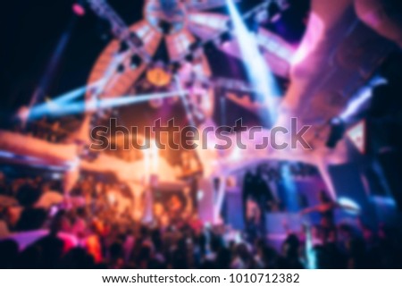 Blurred for background Night club dj party people enjoy of music dancing sound with colorful light with Smoke Machine and lights show. Hands up in the earth.