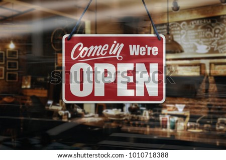 A business sign that says ‘Come in We’re Open’ on cafe/restaurant window
