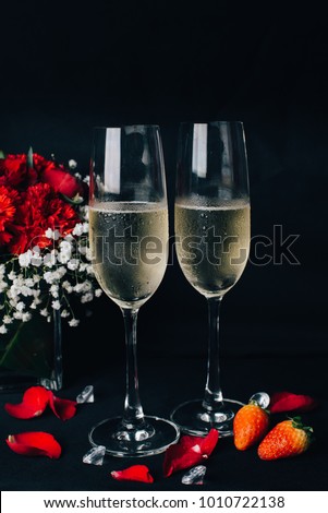 Concept picture for Valentine's day. 2 glasses of Champaign with rose petal, strawbery and flower