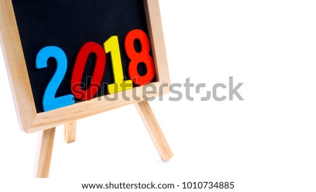 Closeup of wooden black board with colourful word 2018 on white background. Selective focus and crop fragment. 