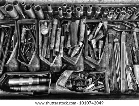 Black and white fine art, top down photo of bike fixing tools in a garage.