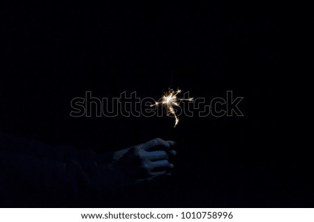 happy holidays.Vintage flim grain Style. Abstract blur background,woman hand holding a burning sparkler light with purple sky background.closeup in female hand in dark.