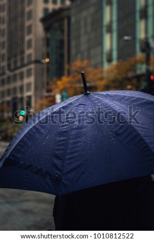 Moody raindrops on a blue umbrella.