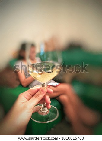 Glass of wine holding on hand and woman background