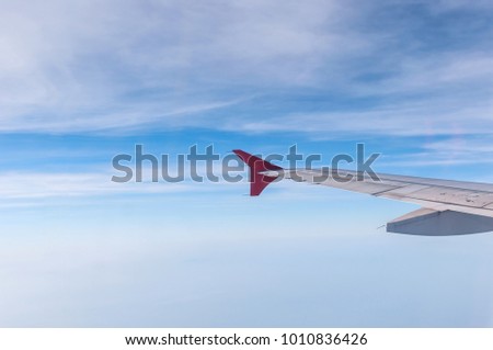 see Airplane wing through the window in sunny weather birds eye view and White cloud on blue sky. travel and freedom concept.