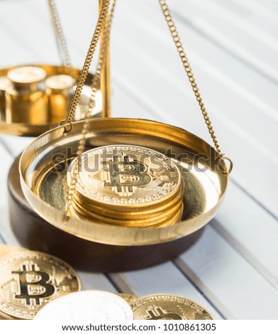 Bitcoin replica with weight scale over white wooden tabletop background