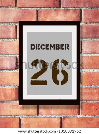 December 26th. 26 December calendar on the wood photo frame with brown brick background. New year at work concept. Winter time.
