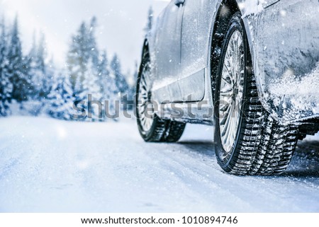 Winter tire. Car on snow road. Tires on snowy highway detail. Royalty-Free Stock Photo #1010894746