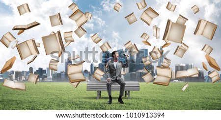 Young businessman sitting on bench and screaming emotionally in megaphone