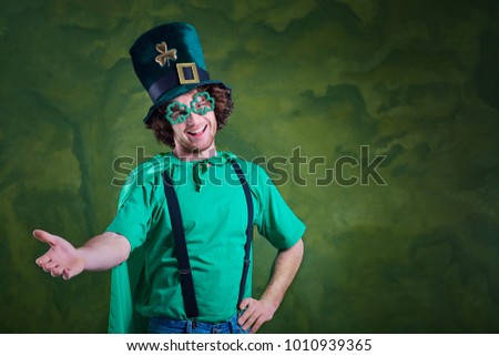 A young curly-haired man in St. Patrick's suit shows his finger 