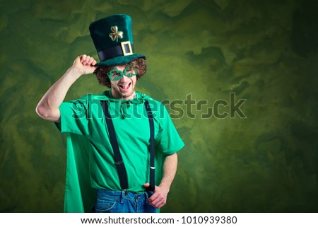 A young curly-haired man in St. Patrick's suit shows his finger 
