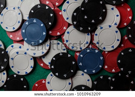 Casino / poker chips colorful gaming pieces lie on the game table in the stack. Background for gambling / casino, business, poker. many colorful casino chips. Casino chips on green velvet. Soft focus.