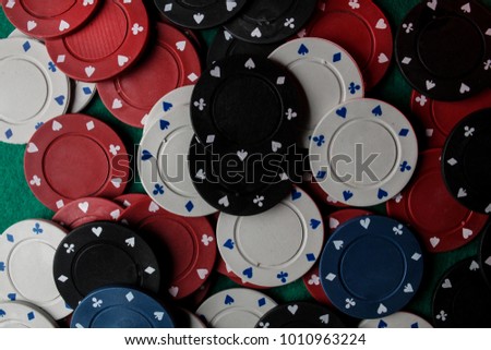 Casino / poker chips colorful gaming pieces lie on the game table in the stack. Background for gambling / casino, business, poker. many colorful casino chips. Casino chips on green velvet. Soft focus.