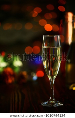 A glass of Sparkling wine in front of defocused colorful lights of dark background 3