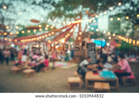 Abstract blur people in night festival city park bokeh background - vintage tone Royalty-Free Stock Photo #1010964832