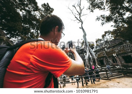 Man is shooting a picture of Ta Prohm temple, Angkor, Cambodia
