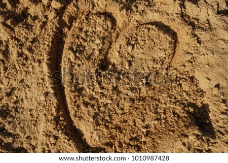 The heart symbol on the sand .