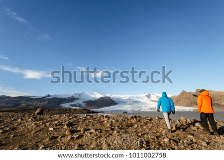 Beautiful cold landscape picture of icelandic glacier lagoon bay. Two men go to the glacier