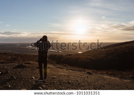 Volcanic landscape with mountains near glacier, South Iceland, man takes pictures