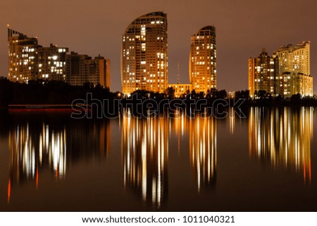 night city with reflection of houses in the river close up