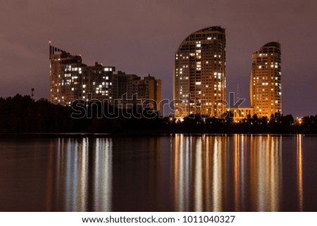 night city with reflection of houses in the river close up