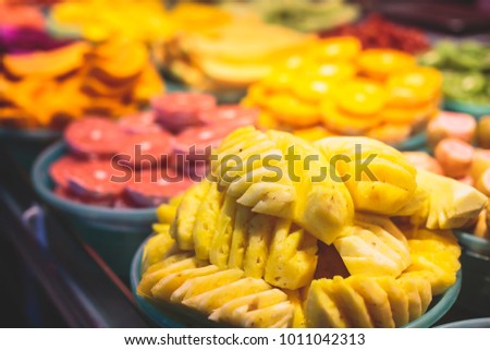 Assortment of different asian fruit: mango, grapefruit, pineapple, passionfruit, melon, watermelon, kiwi, dragon fruit and others sliced and cut on catering banquet table on a party