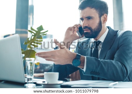 Businessman sitting in a business center restaurant smartphone communication unsatisfied Royalty-Free Stock Photo #1011079798