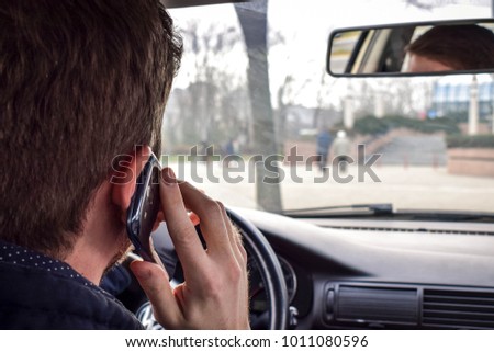 Handsome Man using smartphone while driving the car
