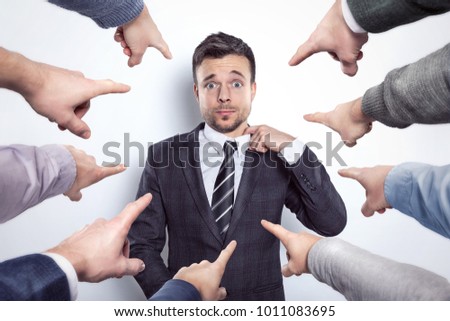 Many fingers pointing at a businessman Royalty-Free Stock Photo #1011083695