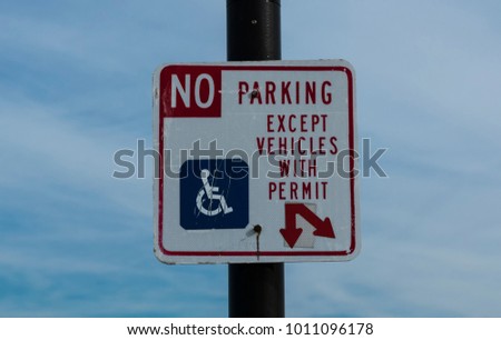 A sign dictating that there is No Parking except for vehicles with a hanicapped permit.