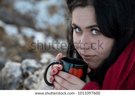 Hipster girl drinking coffee on a mountain top