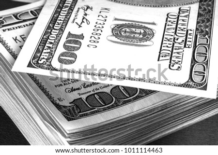 Macro image of US cash money. Hundred US dollar bills. Selective focus. Bills lying on each other.

